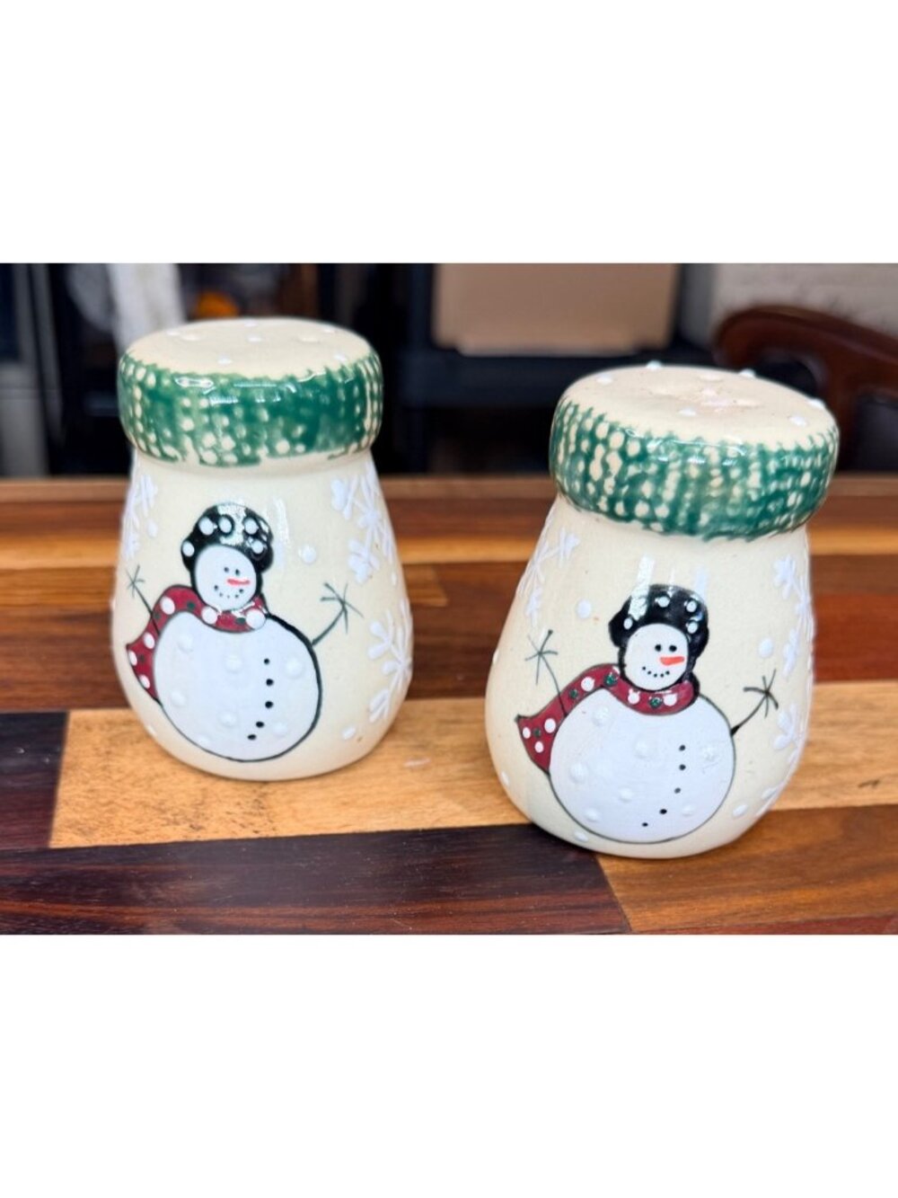 Snowman salt and pepper shakers featuring a painted snowman design with a green